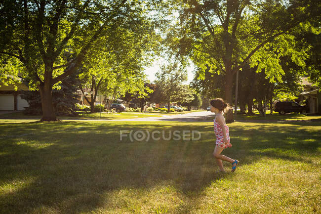 Mädchen spielt an sonnigem Sommertag im Hinterhof — Stockfoto