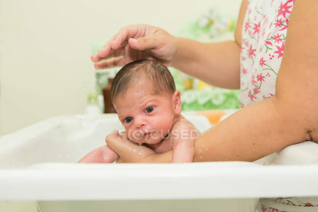 Frau badet ein neugeborenes Baby — Stockfoto