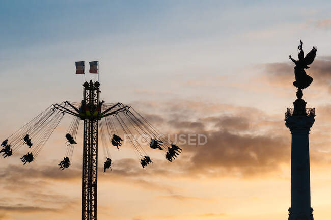 Silhouettes of people at star flyer attraction and Monument aux girondins, Bordeaux, Gironde, France — Stock Photo