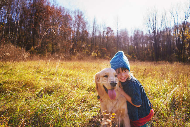 Girl with her golden retriever puppy dog — Stock Photo