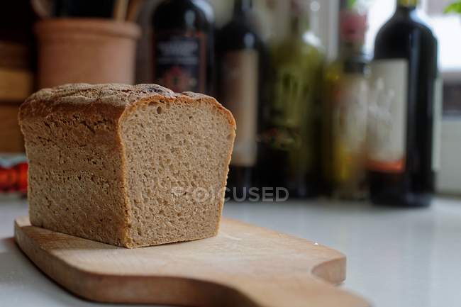 Um pão de pão caseiro numa tábua de cortar — Fotografia de Stock
