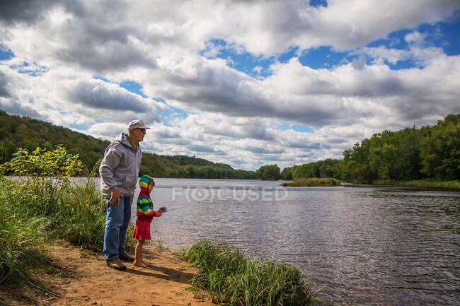 Дедушка рыбачит со своей внучкой. — стоковое фото