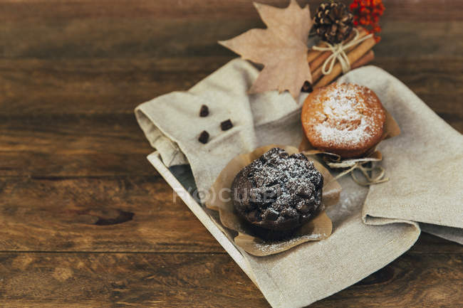 Muffins, dried fruits and spices over wooden table — Stock Photo