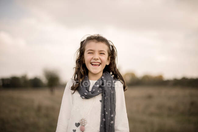 Портрет дівчини, що стоїть на полі, сміється. — стокове фото