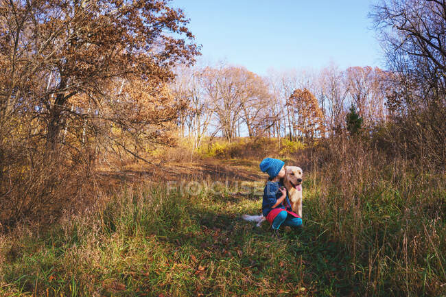 Дівчина цілує свого золотошукача цуценя — стокове фото