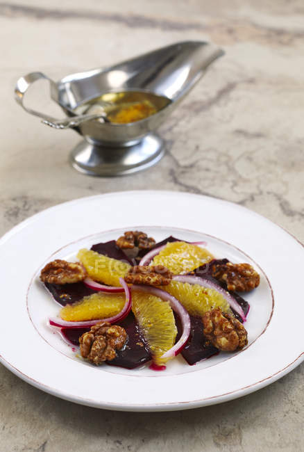 Roasted beet salad with orange slices and caramelized nuts — Stock Photo