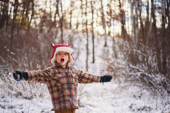 Ritratto di un ragazzo in piedi sulla neve con le braccia tese — Foto stock