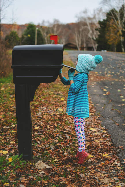 Fille vérifiant la boîte aux lettres dans la rue — Photo de stock
