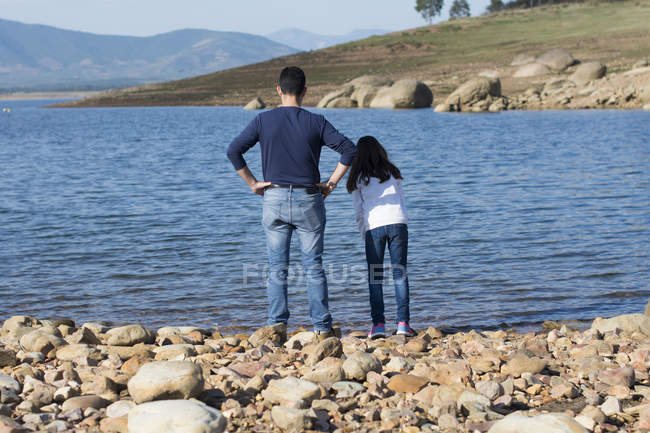 Pai e filha em pé na praia — Fotografia de Stock