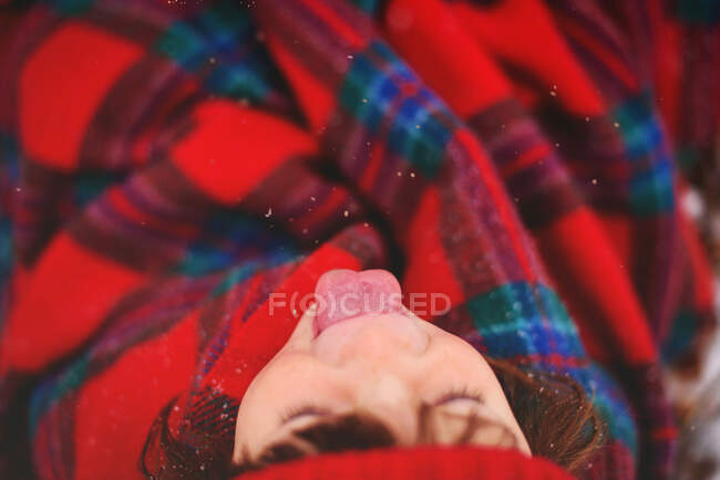 Girl catching snowflakes on her tongue — Stock Photo