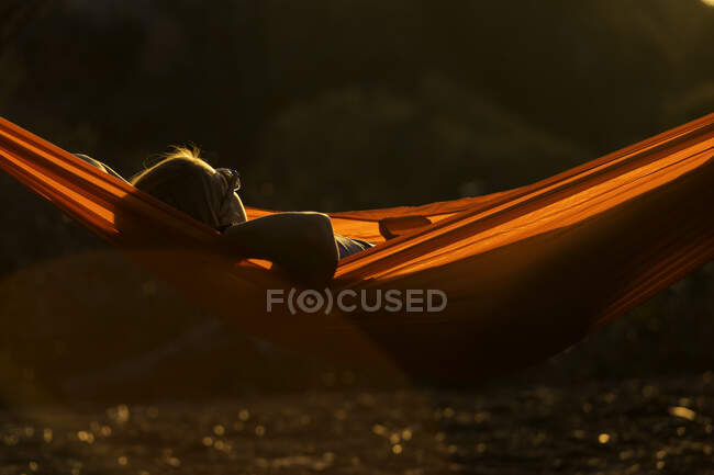 Mulher deitada em uma rede ao sol — Fotografia de Stock