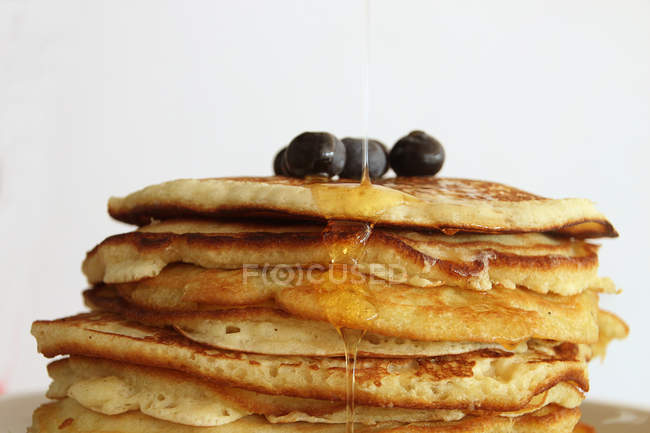 Stack of pancakes with blueberries and honey, closeup view — Stock Photo