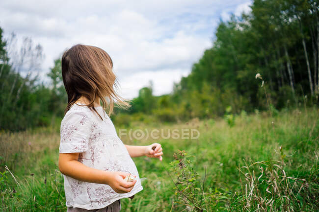 Chica de pie en un campo - foto de stock