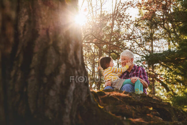 Nonna e nipote seduti nella foresta a parlare — Foto stock