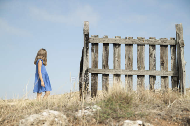 Дівчинка йде повз паркан. — стокове фото
