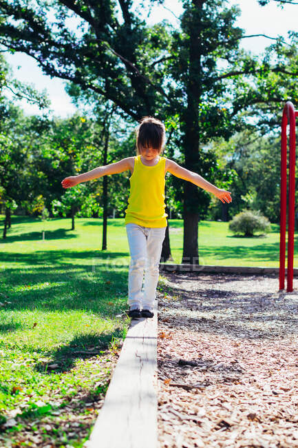 Дівчина балансує на дерев'яному паркані — стокове фото