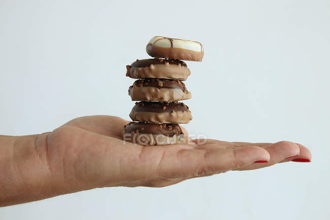 Mão segurando pilha de cookies de chocolate — Fotografia de Stock