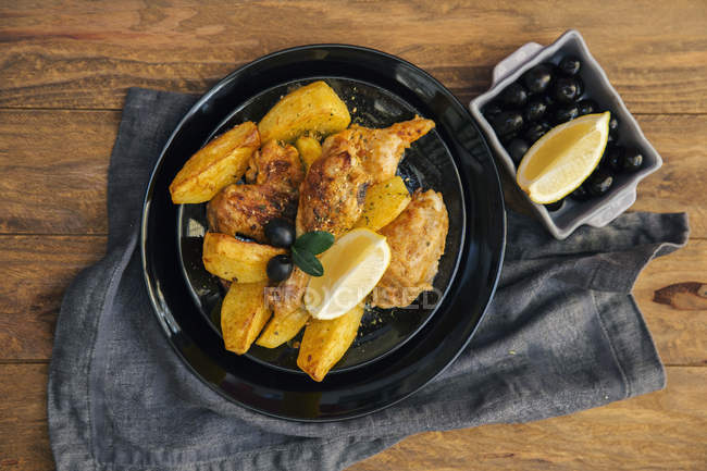 Roast chicken with roast potatoes and olives — Stock Photo