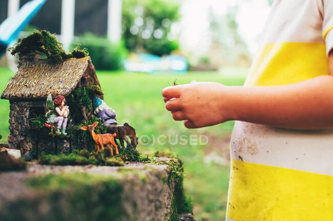 Menina brincando com brinquedos de fadas jardim — Fotografia de Stock