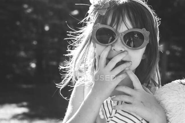 Портрет дівчини в сонцезахисних окулярах своїми руками на її обличчі — стокове фото