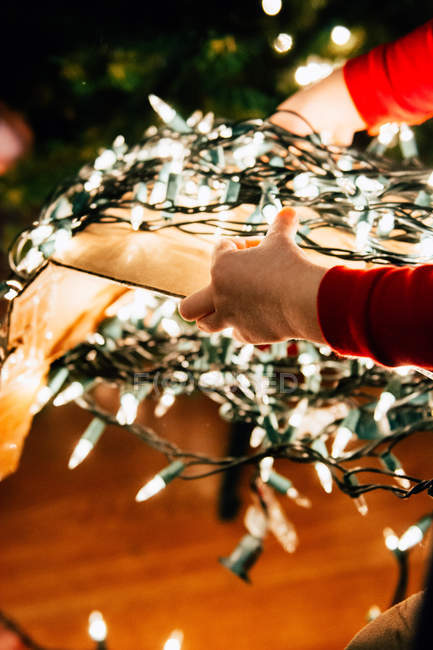 Imagen recortada de Chica sosteniendo luces de Navidad - foto de stock