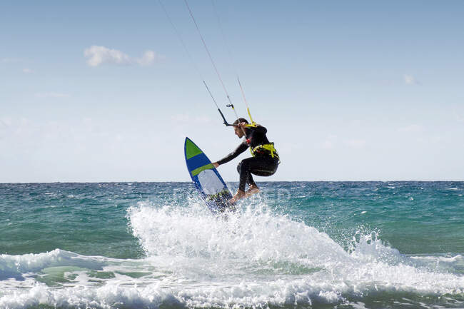 Kitesurf de hombre con tabla de surf sin tirantes, Playa de Los Lances, Tarifa, Cádiz, Andalucía, España - foto de stock