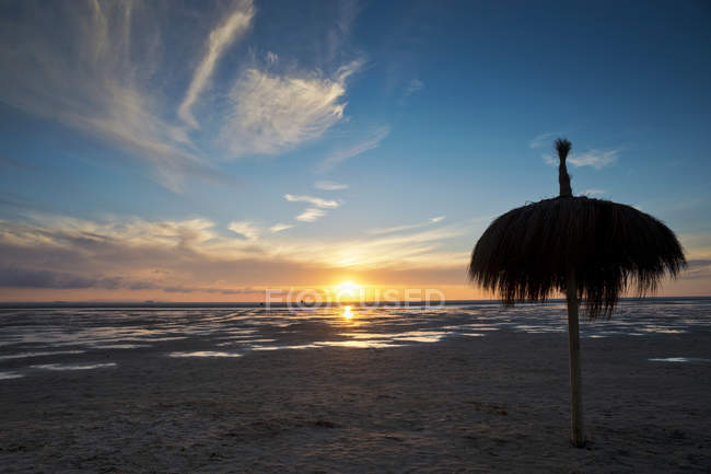Parasol on Los Lances Beach at sunset — Stock Photo