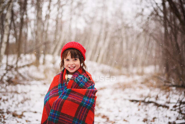 Portrait d'une fille enveloppée dans une couverture debout dans la neige — Photo de stock