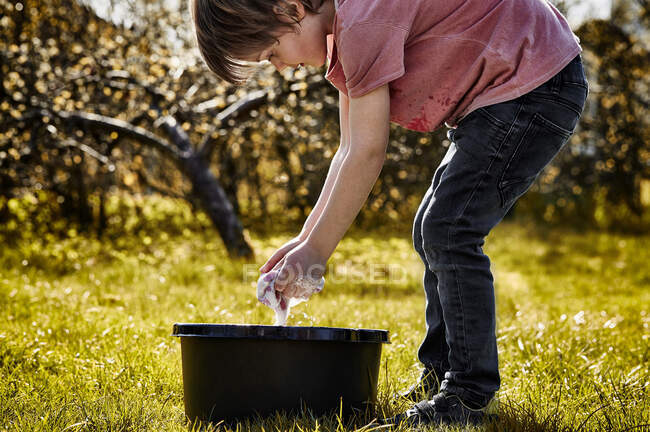 Мальчик моет руки в миске с мылом и водой — стоковое фото