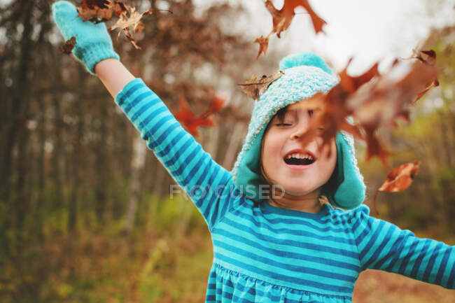 Дівчина кидає осіннє листя в повітрі на природу — стокове фото
