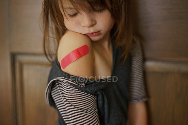 Depressed girl with plaster on her arm — Stock Photo