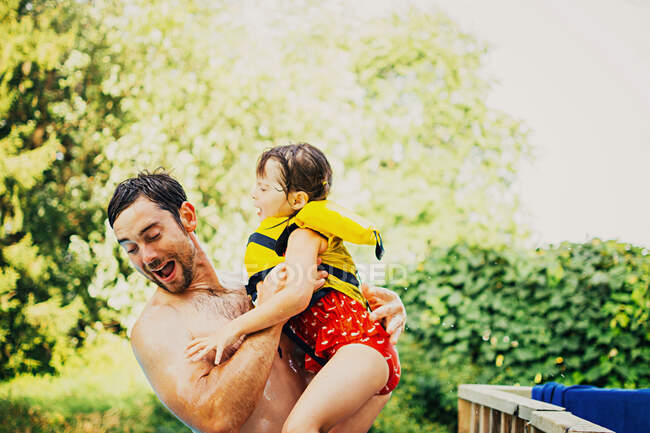 Батько стрибає в басейн з дочкою. — стокове фото