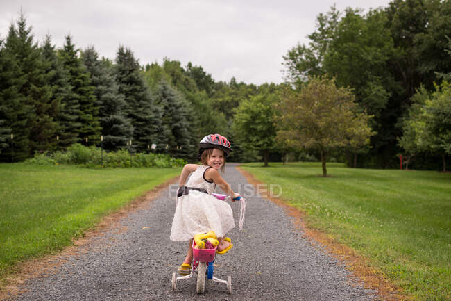Дівчина їде на велосипеді зі стабілізаторами — стокове фото