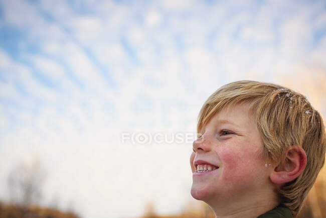 Retrato de un niño con copos de nieve en el pelo - foto de stock