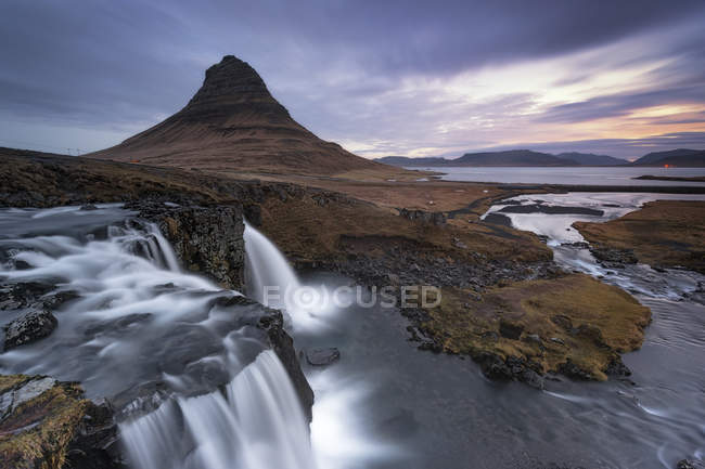 Kirkjufellsfoss e Kirkjufell montanha ao nascer do sol, Islândia — Fotografia de Stock