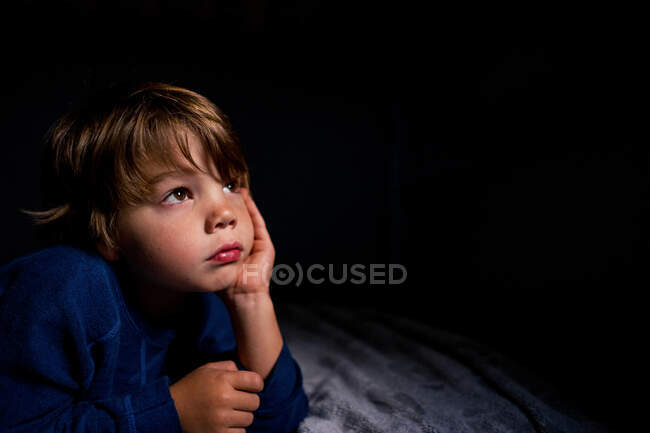 Retrato de un niño apoyado en su codo - foto de stock
