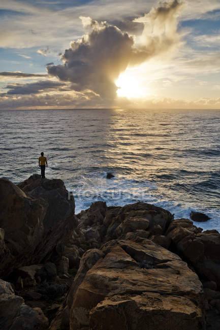 Homme debout sur des rochers au bord de l'océan, Bolonia, Cadix, Andalousie, Espagne — Photo de stock