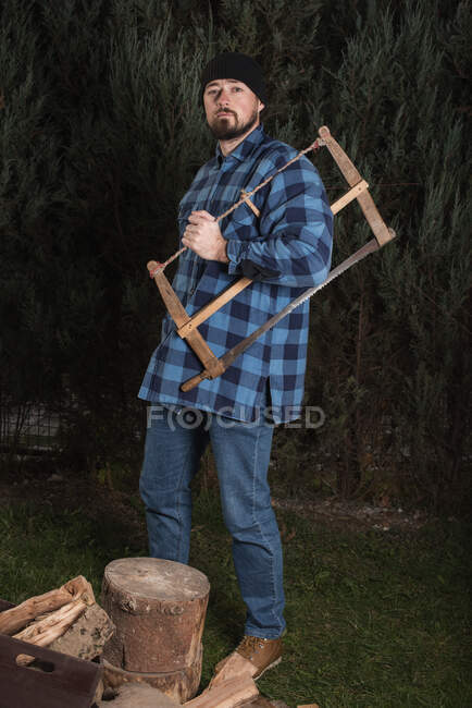 Homem carregando uma serra — Fotografia de Stock