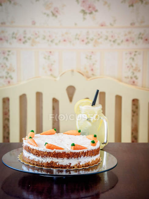 Carrot cake with a lemonade drink over table at kitchen — Stock Photo
