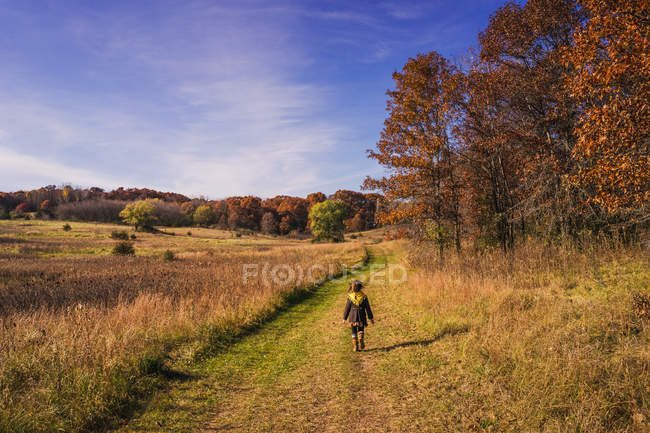 Passeggiata della ragazza lungo il sentiero della natura in autunno — Foto stock