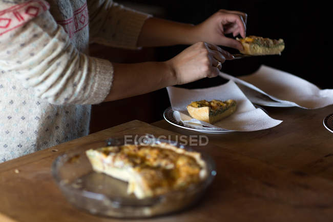 Frau serviert Scheiben Frühstücksquiche — Stockfoto