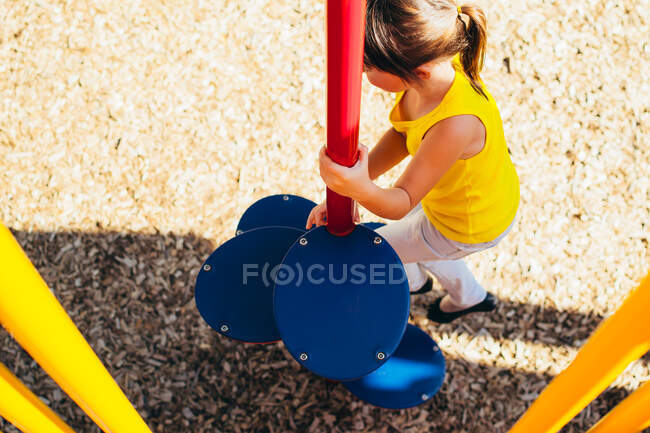 Девочка, играющая на детской площадке под открытым небом — стоковое фото
