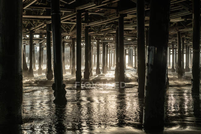 Vista panorámica de los postes de madera debajo del muelle, Santa Monica, California, América, Estados Unidos - foto de stock