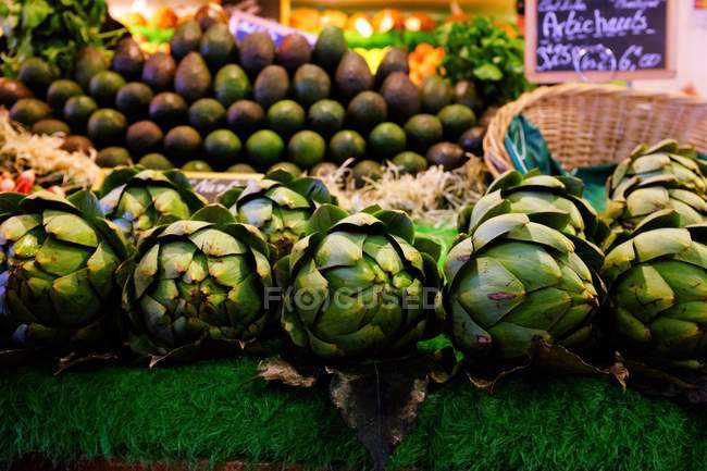 Artichokes and avocados at market — Stock Photo