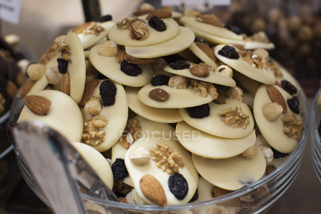 White chocolate heap with nuts and raisins — Stock Photo