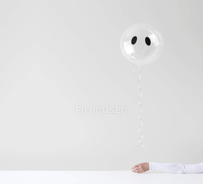 Main de femme tenant un ballon fantôme — Photo de stock