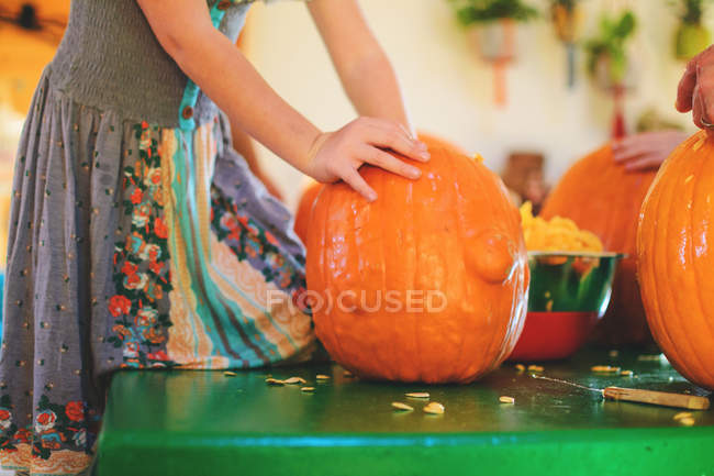 Girl scooping out pumpkin for Halloween — Stock Photo