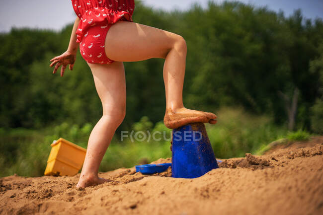 Menina brincando na areia na praia — Fotografia de Stock