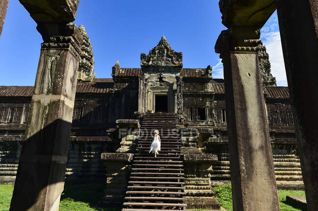 Rückansicht einer Frau, die die Treppe zum Tempel hinaufgeht — Stockfoto