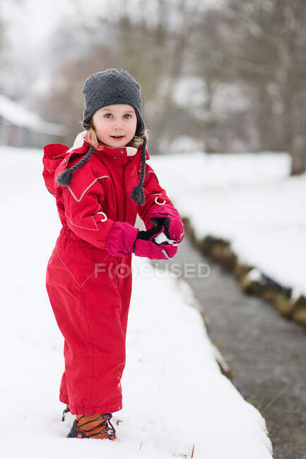 Adorável menina feliz jogando na neve — Fotografia de Stock